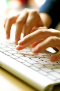 Hands and computer close up.